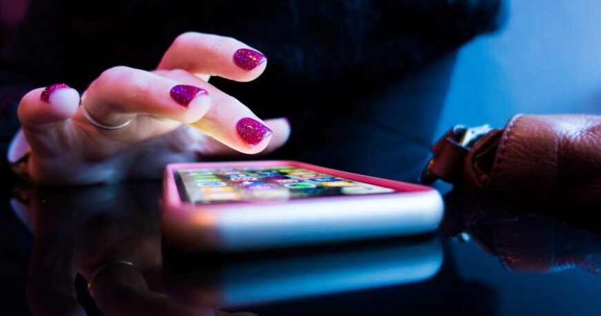 person using black smartphone with gray and pink case