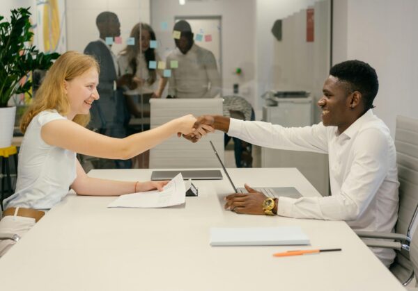 Free Business professionals completing a successful deal with a handshake in a modern office setting. Stock Photo